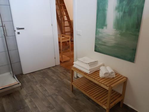 a room with a table with towels and a painting at Aqua Apartments Spa Housemuhlbach in Sappada