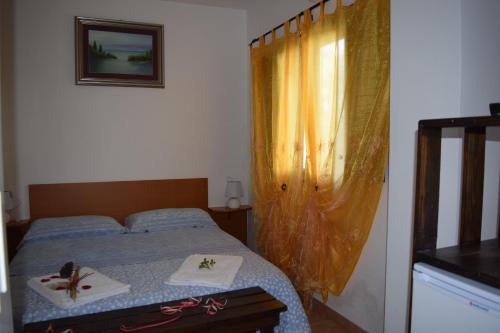 a bedroom with a bed with two towels and a window at Villaggio Camping Bosco Selva in Alberobello