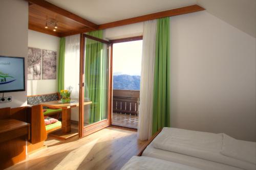 a bedroom with a bed and a large window at Mathiasl Panorama Ferienwohnungen in Bodensdorf