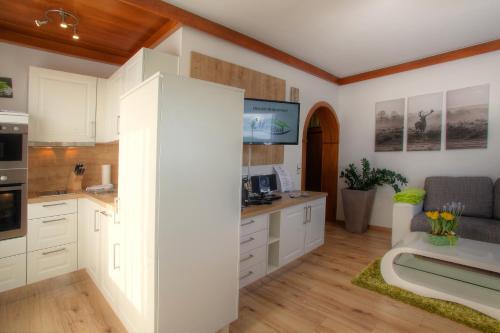 a large kitchen with white cabinets and a couch at Mathiasl Panorama Ferienwohnungen in Bodensdorf