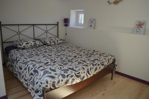 - un lit avec une couette en noir et blanc dans une chambre dans l'établissement Gîtes La ferme accrochée à la colline, à Lagorce