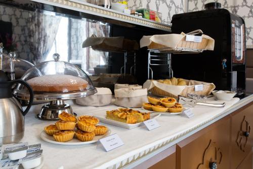 a bakery counter with pastries and cakes on a table at Hotel Ca' Nobile Corner in Venice