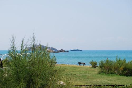 a bench sitting on the beach near the water at Sul mare di Punta Ala in Punta Ala