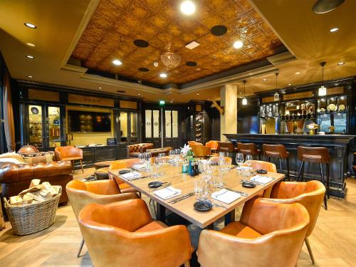 a dining room with a long table and chairs at Brasserie-Hotel Antje van de Statie in Weert