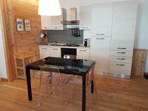 a kitchen with a black table and a stove at Aqua Apartments Spa Housemuhlbach in Sappada