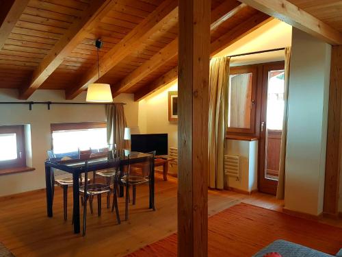 a dining room with a black table and chairs at Aqua Apartments Spa Housemuhlbach in Sappada