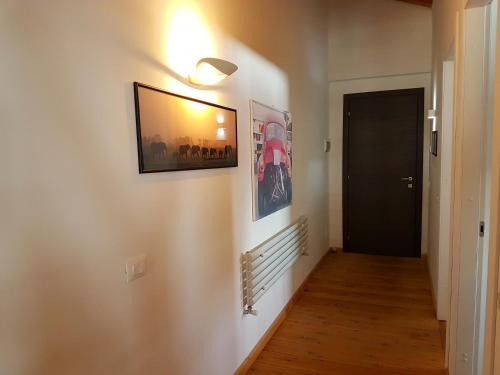 a hallway with two pictures on the wall and a door at Aqua Apartments Spa Housemuhlbach in Sappada