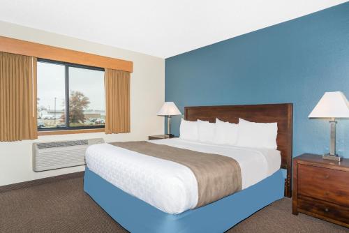 a hotel room with a large bed and a window at Days Inn & Suites by Wyndham Baxter Brainerd Area in Baxter