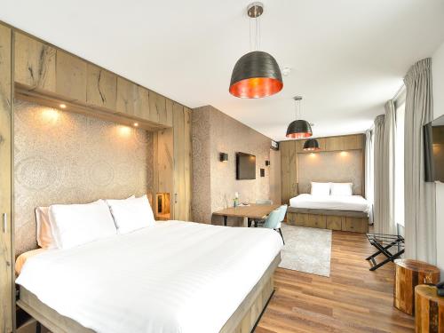 a hotel room with two beds and a tv at Brasserie-Hotel Antje van de Statie in Weert