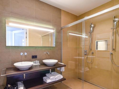 a bathroom with two sinks and a shower at Brasserie-Hotel Antje van de Statie in Weert