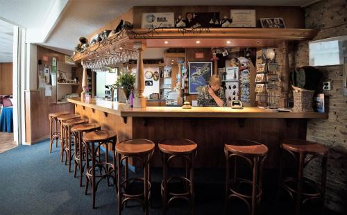 una fila de taburetes en un bar en un restaurante en Hostel Herberg de Esborg Scheemda en Scheemda