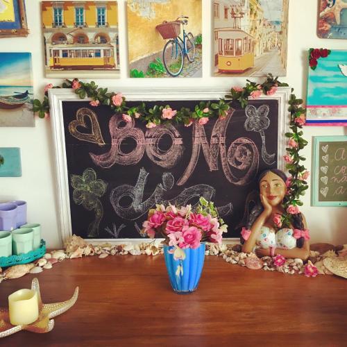 a table with a vase of flowers and a chalkboard at Canto das Laranjeiras Villa in Guarujá