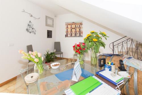 a dining room table with vases of flowers on it at B&B Albergo Sicilia in Avola