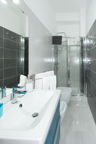 a white bathroom with a sink and a toilet at B&B Albergo Sicilia City Center in Avola