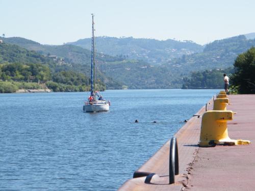 a sail boat in the water next to a dock at Douro Marina Hotel & SPA in Resende