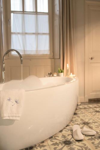 a white bath tub in a bathroom with a window at Jardí de Ses Bruixes Boutique Hotel in Mahón