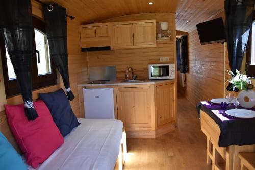 Cette petite chambre comprend un lit et une cuisine. dans l'établissement La Roulotte des Bords de l'Ance, à Tiranges