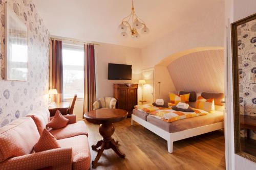 a bedroom with a bed and a table and a couch at Hotel Haus Müller in Marburg an der Lahn