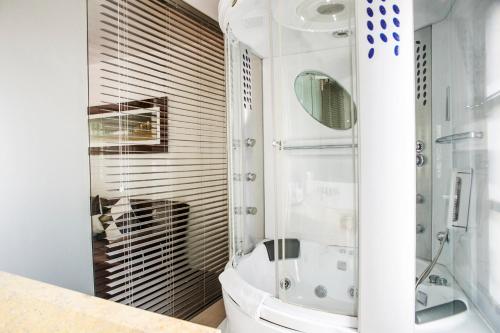 a bathroom with a toilet and a glass shower at Hotel Virrey Park in Bogotá