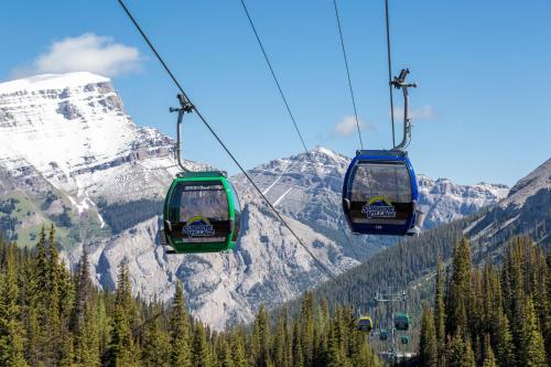 two gondolas on a ski lift in front of a mountain at Sunshine Mountain Lodge in Banff