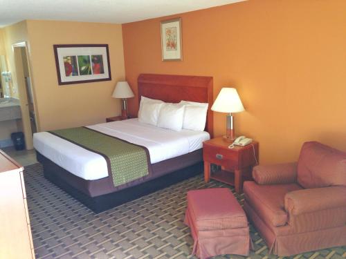 une chambre d'hôtel avec un lit et une chaise dans l'établissement Inn Cheraw, à Cheraw