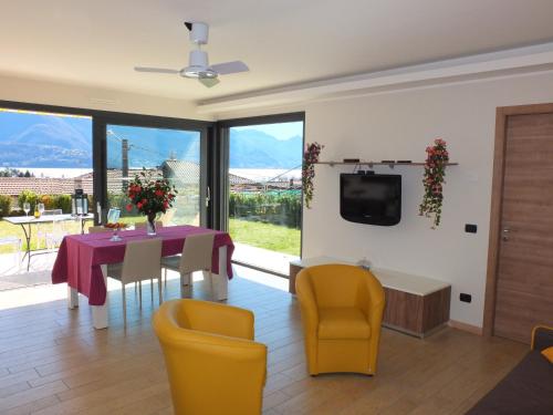 a living room with a table and chairs and a tv at BELLA VITA Residence in Gravedona