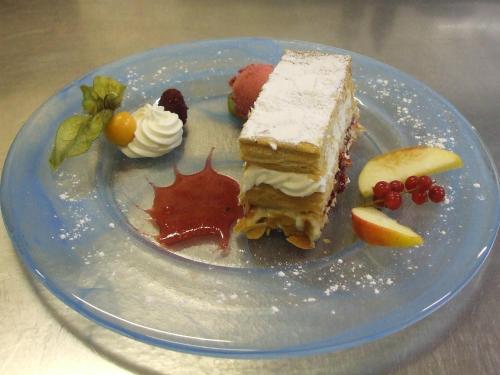 a blue plate with a piece of cake and fruit at Hôtel de la Baie des Trépassés in Plogoff
