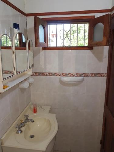 a bathroom with a sink and a toilet and a window at Loft en Casona Colonial in Santa Rosa