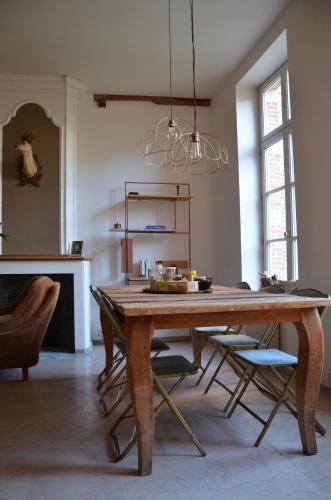 een eetkamer met een houten tafel en stoelen bij B&B De Vrome Vos in Mechelen