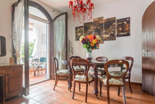a dining room with a table with chairs and a vase of flowers at Gangdigiorgia in Capitana