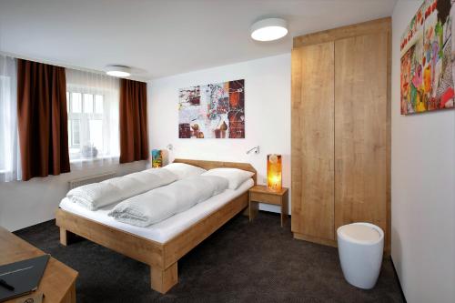 Wohlfühlappartements Bayer في باد شاليرباخ: غرفة نوم بسرير وخزانة خشبية