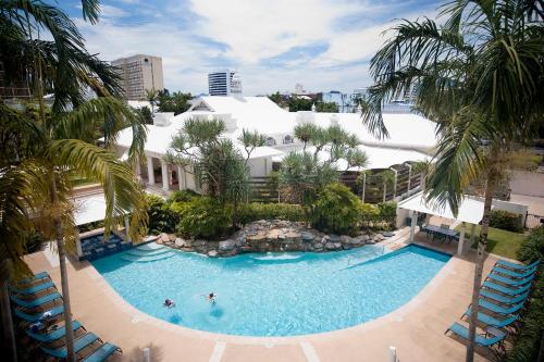 an overhead view of a swimming pool with palm trees at Mantra Esplanade in Cairns