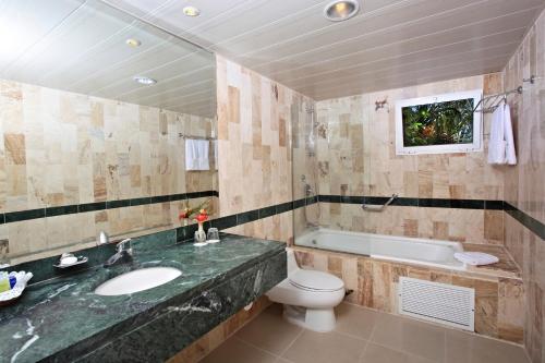 a bathroom with a sink and a toilet and a tub at Eurostars Grand Cayacoa in Santa Bárbara de Samaná
