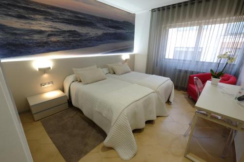a bedroom with a bed and a painting on the wall at Hotel Vila da Guarda in A Guarda