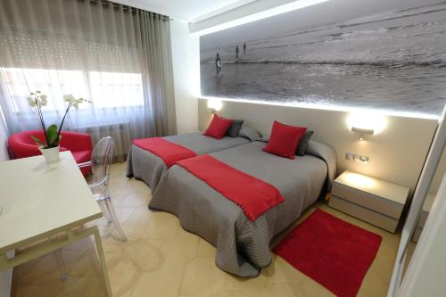 a bedroom with a bed with red pillows at Hotel Vila da Guarda in A Guarda