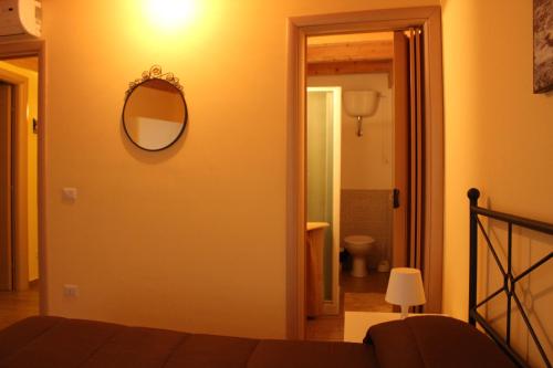 1 dormitorio con espejo en la pared y 1 cama en Terrazza Sul Rabato, en Agrigento