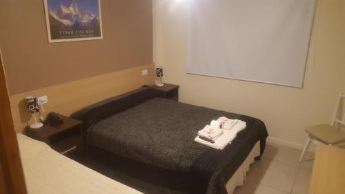 a bedroom with a bed with towels on it at Hotel Europa in Mar del Plata