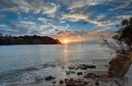 a sunset over the water with a rocky beach at Royalton Saint Lucia, An Autograph Collection All-Inclusive Resort in Gros Islet