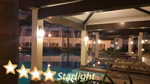 a hotel with a swimming pool at night at StayCation Dream CondoTel in Manila