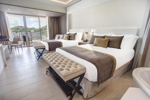 a hotel room with two beds and a bathroom at Royalton Hideaway Saint Lucia, An Autograph Collection All-Inclusive Resort - Adults Only in Gros Islet