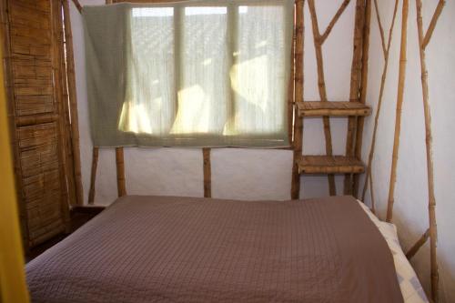 a bedroom with a bed and a window and two chairs at Hotel La Montoya in Curití