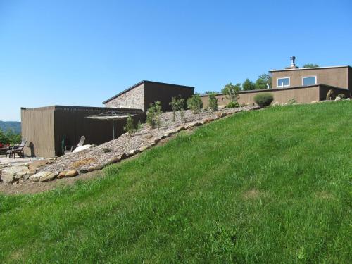 a grassy hill with a house on top of it at 13 Hills Bed & Breakfast in South Acworth