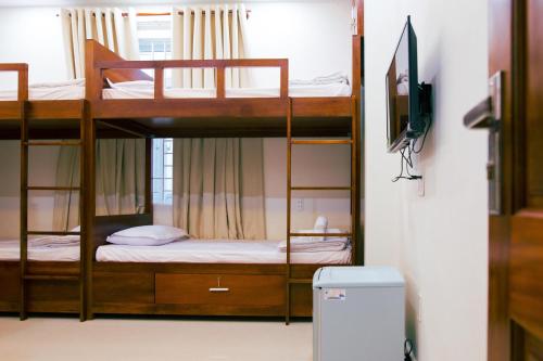 two bunk beds in a room with a television at Nhat Nga Hotel in Vung Tau
