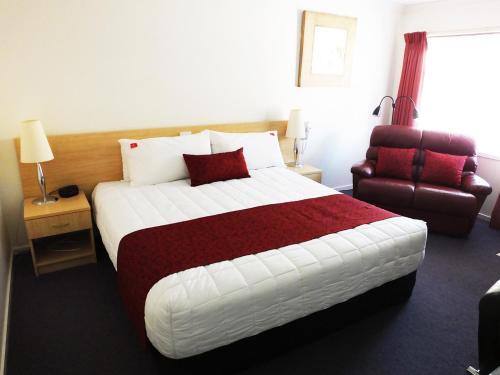 a hotel room with a bed and two night stands at Edinburgh Motor Inn in Warragul