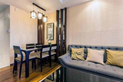 a dining room with a table and a blue couch at Relaxing Wind in Tagaytay