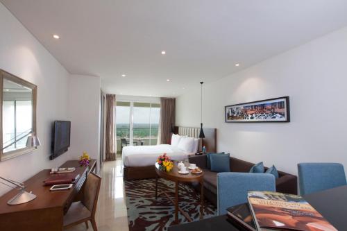 a hotel room with a bed and a living room at Oakwood Residence Whitefield Bangalore in Bengaluru