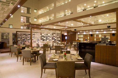 a dining room with tables and chairs in a restaurant at Oakwood Residence Whitefield Bangalore in Bengaluru