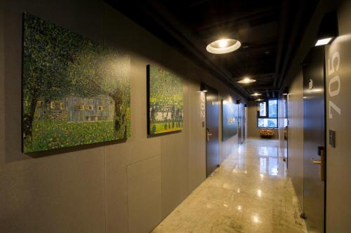 a hallway with paintings on the walls of a building at Grid Inn Hotel in Seoul