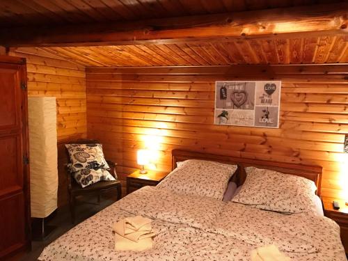ein Schlafzimmer mit einem Bett in einer Holzhütte in der Unterkunft Dachsbau in Barbis