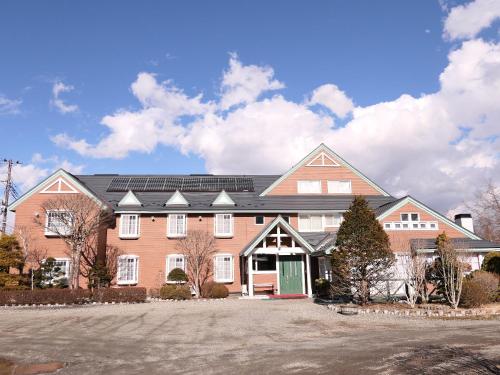 a large house with solar panels on the roof at Pension Avenue in Yamanakako